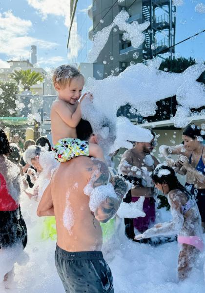 Bambini giocano in una festa di schiuma all'aperto.