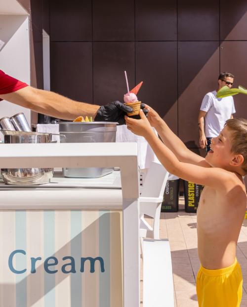 Bambini prendono gelato da un chiosco all'aperto.