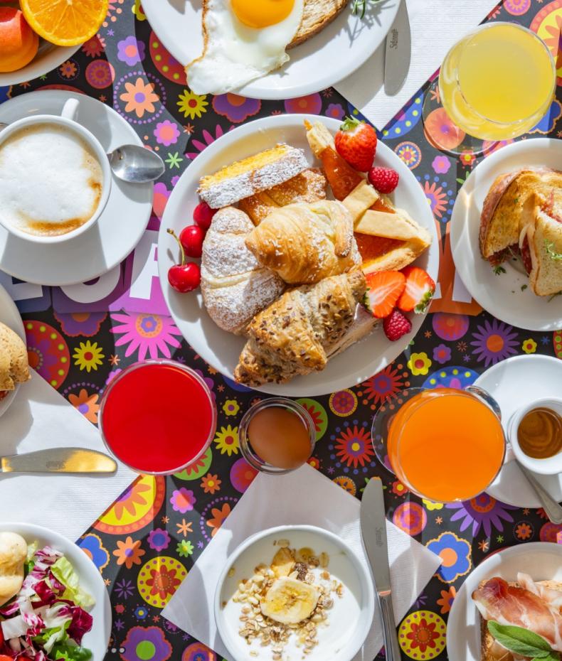 Colazione variopinta con dolci, frutta, uova e bevande.