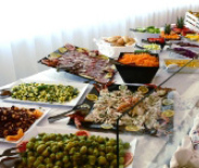 Buffet ricco di verdure, salumi e salse su un tavolo elegante.