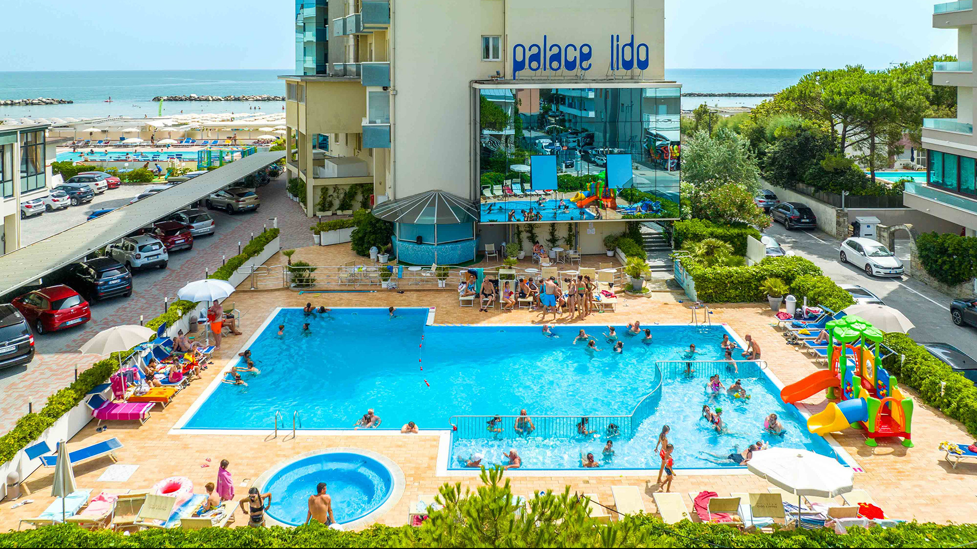 Piscina per bambini con giochi e gonfiabili in un ambiente colorato e divertente.