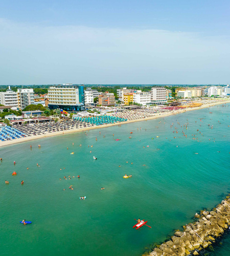 Plage bondée, mer turquoise, joie estivale, détente sous le soleil.