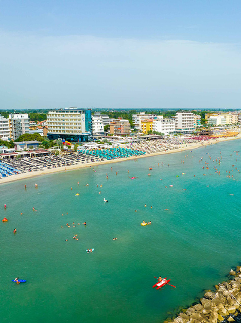 Plage bondée, mer turquoise, joie estivale, détente sous le soleil.