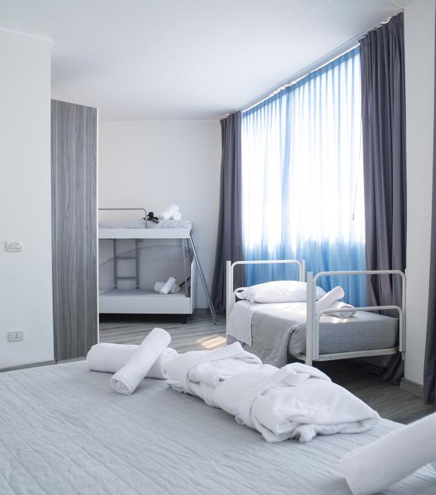 Famiglia felice in una stanza, bambina con peluche su letto a castello.