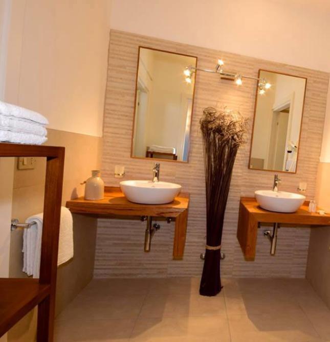 Elegante bagno moderno con doppi lavandini e doccia in vetro.